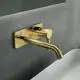 Wandarmatur in gebürstetem Gold von Ideal Standard, mit eckiger Rosette und einem leicht gebogenen Auslauf. Ideal für moderne Waschbecken.